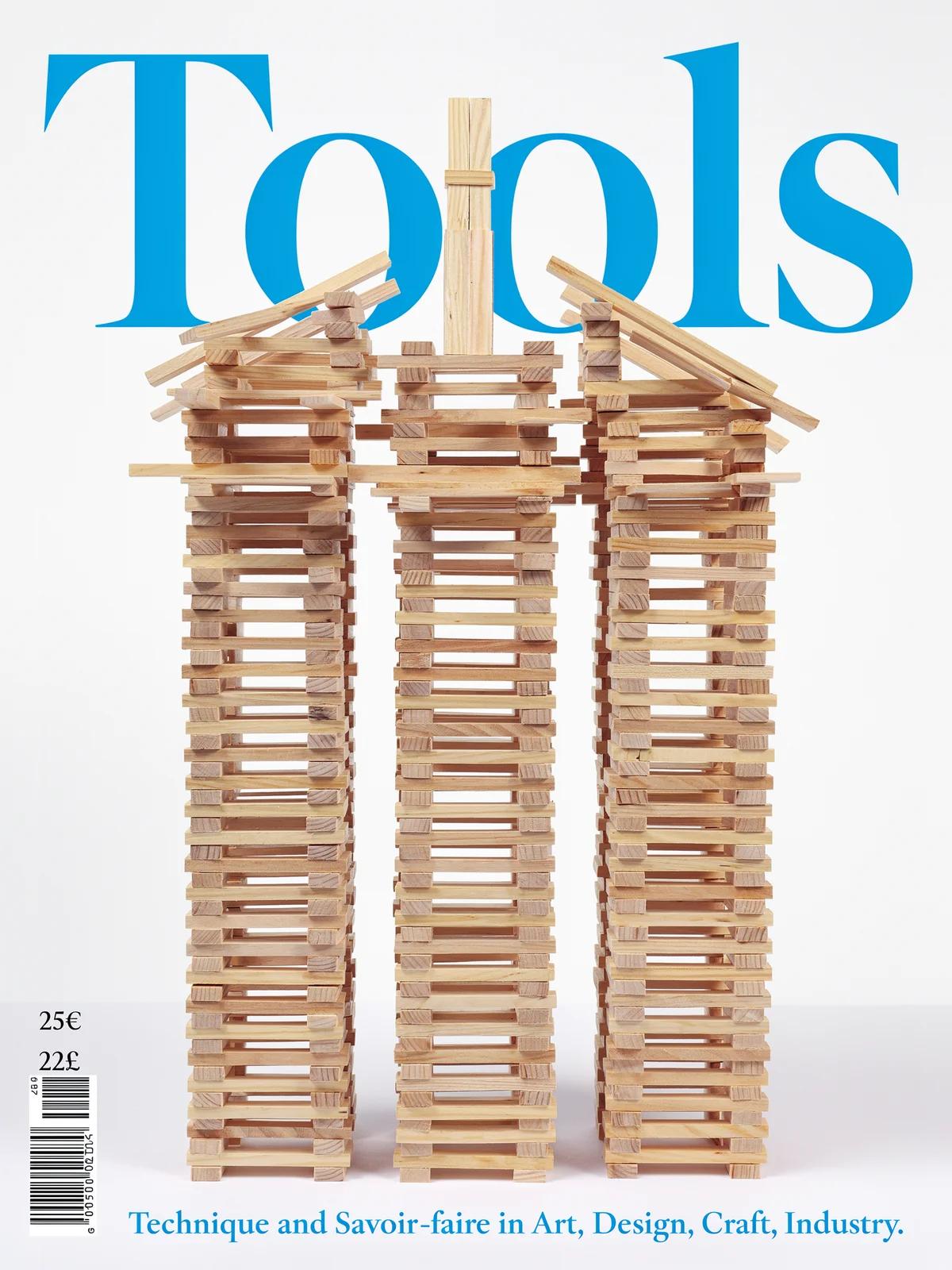A design journal cover titled Tools in blue serif, with three towers of stacked wooden planks on white.